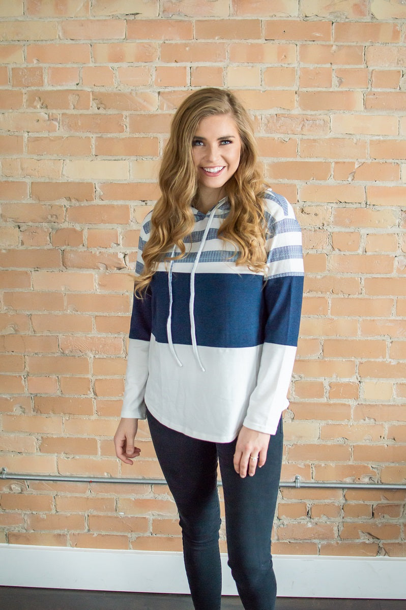 Model facing forward wearing striped hoodie